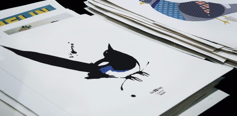Photograph of a bunch of posters, the first with the Marica illustration.