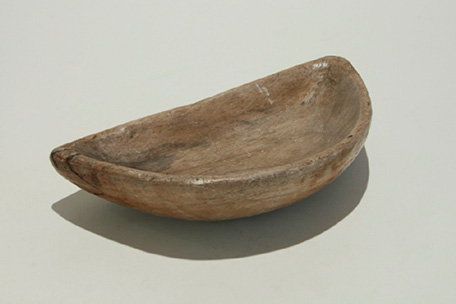 Qulleq de las Inuit. Recipiente plano fabricado con piedra esteatita, color marrón sobre fondo blanco.