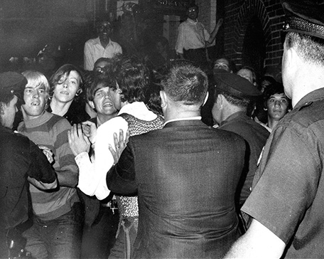 La gente enfrentándose a la policía frente al Stonewall Inn. Fotografía en blanco y negro.