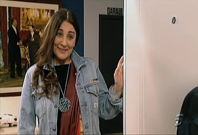 Fotograma de la serie de televisión española "La que se avecina". Araceli Madariaga, bien podría ser una Earthy-crunchy dyke, en el vano de una puerta con su cara de infinita comprensión.
