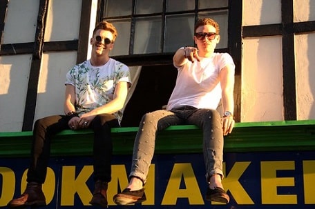 How many people are gay. Two guys sitting on the Bookmaker's marquee. One of them points to you.