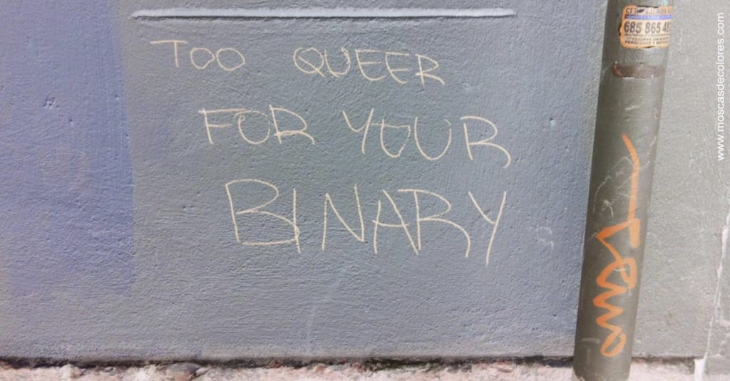 Too queer for your binary. Grafiti en el centro de Valencia, sobre una pared lila con una tubería bajante.
