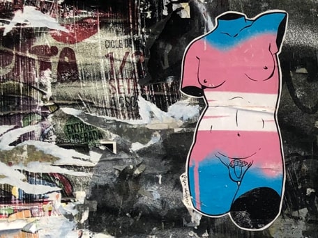Arte urbano en Valencia. Una estatua clásica, con senos y pene, pintada de los colores de la bandera transgénero, nos ilustra categorías como hombre, mujer, lesbianas activas y pasivas, masculino y femenino.