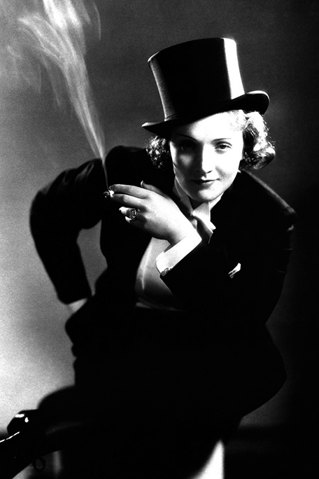 Photo of Marlene Dietrich dressed as a man and smoking, like a Kesser Vater. Black and white photo.